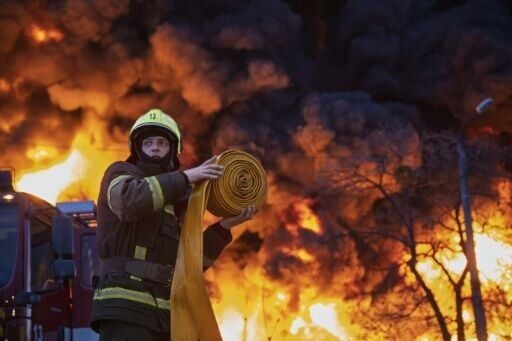 A firefighter works to extinguish a blaze at a recycling materials site following a Russian strike in Kyiv