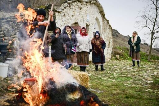Local women watch the pig being roasted for the Christmas celebration in Rogojeni