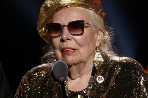 Canadian singer-songwriter Joni Mitchell wears an 'Ice Out' pin as she accepts the Grammy for best historical album