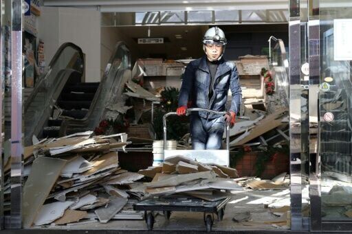 A worker clears debris at a shopping center damaged by the earthquake in Hachinohe City, Aomori Prefecture on December 9, 2025