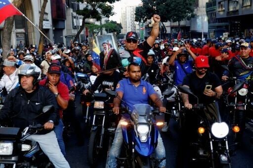 Government supporters ride motorcycles during a march one month after the ouster of Venezuelan President Nicolas Maduro demanding his release