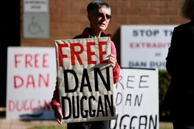 A supporter of Daniel Duggan, a former US Marines pilot accused of illegally training China's military, holds a placard outside the Federal Court of Australia in Canberra on April 16, 2026