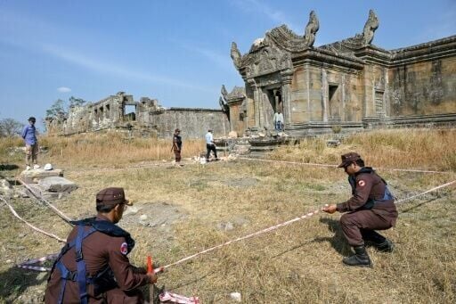 Deminers from the Cambodian Mine Action Centre use tape to mark an area around unexploded ordnance at the Preah Vihear temple