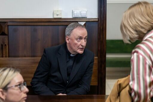 Bishop Andrzej Jez speaks with Lilianna Kupaj (right), who was abused by a priest as a child, in court