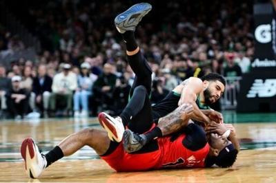 Jayson Tatum of the Boston Celtics and Ja'kobe Walter battle for the ball in the Celtics' NBA win over the Toronto Raptors