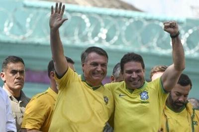 Ramagem (R, with fist raised) commanded Brazil's main intelligence agency during Jair Bolsonaro's presidency