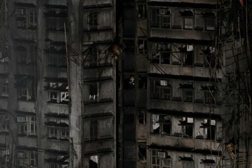 A firefighter walks inside an apartment after a major fire that swept through several apartment blocks