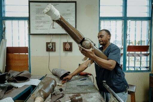 Andre Mbuguja, an ortho-prosthetist who was cared for by the centre, tinkering with a prosthesis