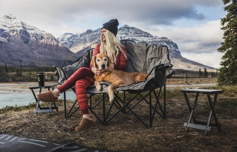 Woman and dog sitting in camp chair