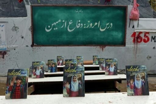 A memorial in Tehran depicts a symbolic classroom representing the killing of school children in a strike at the start of the war