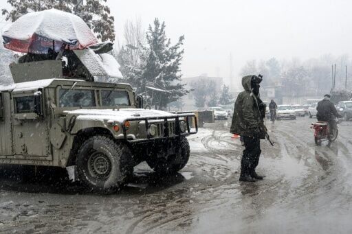 A Taliban security personnel stands guard at a checkpoint during snowfall in Kabul on January 22, 2026.