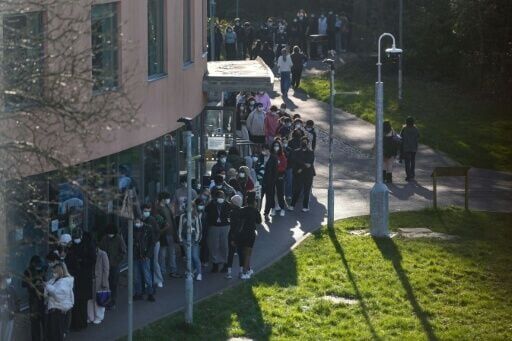 Students wearing face masks queue up for vaccines at the University of Kent in Canterbury, southeast England amid a deadly outbreak of meningitis