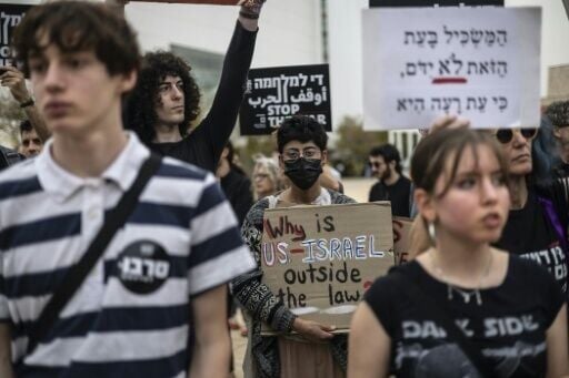 Protesters hold banners during an anti-war protest in Tel Aviv on Saturday