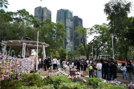 People pay their respects for the victims of a deadly fire at the Wang Fuk Court residential estate in Hong Kong's Tai Po district