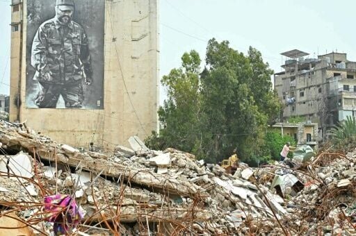 A resident inspects the rubble of destroyed buildings on his return to the southern Lebanese city of Nabatieh