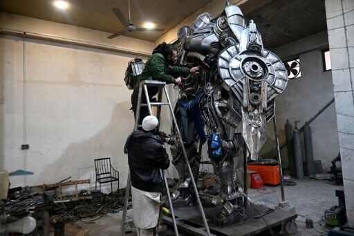 Sculptor Ehtisham Jadoon spray paints a model of Optimus Prime, a film character from Transformers, made from scrap metal at his studio