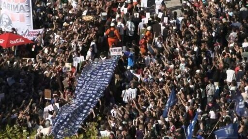Demonstrators carry a large banner with portraits of disappeared people during a march to Plaza de Mayo