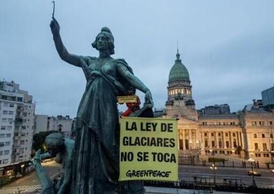 A Greenpeace activist unfurls a banner reading 'Hands off the Glaciers Law' outside Argentina's parliament ahead of a vote by MPs on an amendment watering down glacier protections