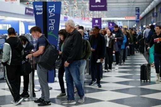 Travelers wait in line at a security checkpoint at O'Hare International Airport in Chicago, Illinois on November 7 2025