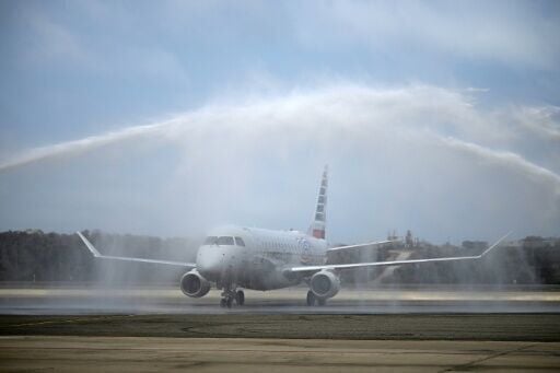 An American Eagle aircraft receives celebratory sprays of water after landing in Venezuela as the first direct flight from the United States in years