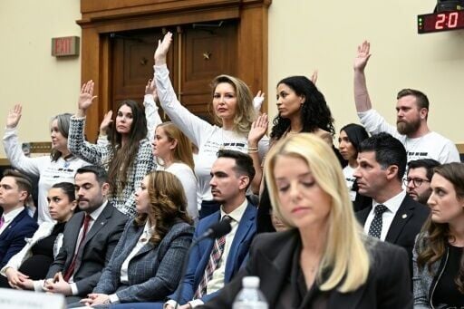 Victims of convicted sex offender Jeffrey Epstein react as US Attorney General Pam Bondi (foreground) testifies before the House Judiciary Committee