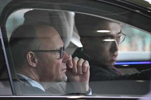 German Chancellor Friedrich Merz (L) takes part in an autonomous driving test of a Mercedes S-Class in Beijing on February 26, 2026.