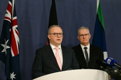 Australia's Prime Minister Anthony Albanese (L) speaks on the Royal Commission on last year's mass shooting incident where two gunmen killed 15 people at Australia's Bondi Beach, while Home Affairs Minister Tony Burke (R) looks on during a press confere...