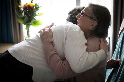 Rachel Fournier hugs her goddaughter Emilie Laroche at a palliative care center in Boucherville, Canada