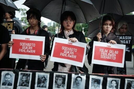 Activists protest the decision to name former dictator Suharto a national hero