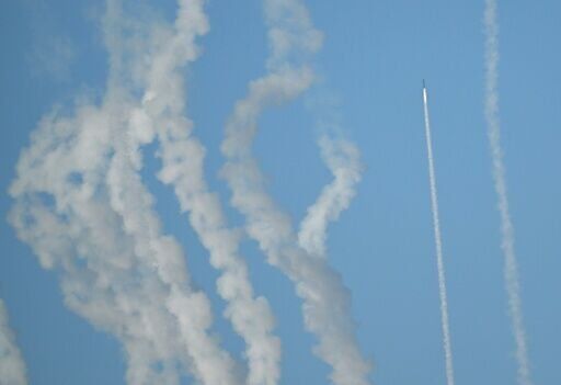 A rocket and plumes of smoke are seen in the sky above Pingtan as the Chinese People's Liberation Army conduct military drills