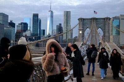 People brave the cold on the Brooklyn Bridge in New York City ahead of Winter Storm Fern