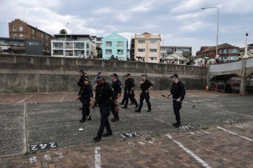 Police officers patrol near a small bridge where gunmen stood during a mass shooting in Bondi Beach last Sunday.