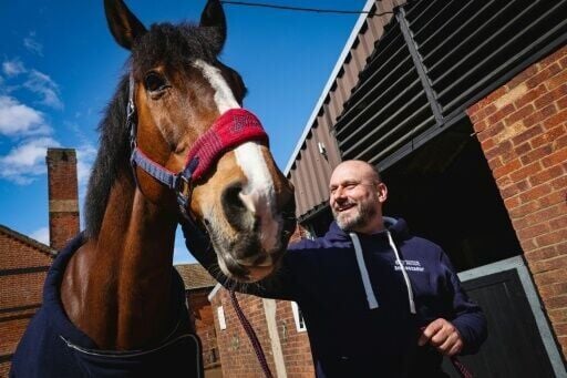 Police Inspector Nick Morton, who was diagnosed with complex PTSD after a mental health breakdown, pats a horse following a exercise to gain the trust of the animal at The Light Cavalry Honorable Artillery Company stables