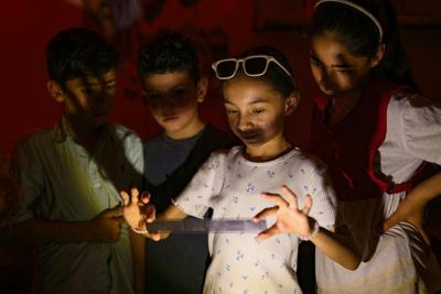 Children look at developed film in a darkroom during an analog photography workshop held in southeastern Turkey on June 14, 2026.