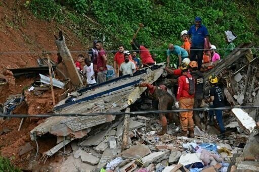Rescue teams remove debris as they search for victims of a landslide in in Juiz de Fora following torrential rains
