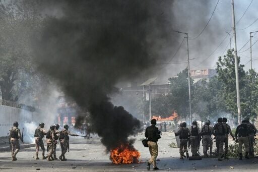 Security personnel fire tear gas as Shiite Muslims shout slogans during a protest outside the US consulate in Karachi on March 1, 2026 after the death of Iran's supreme leader Ayatollah Ali Khamenei amid US-Israel strikes