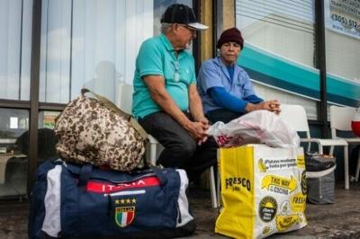 People line up with packages and items to send to Cuba at a Cubamax store in Florida