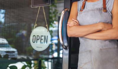 Woman waiting next to open sign from ADN