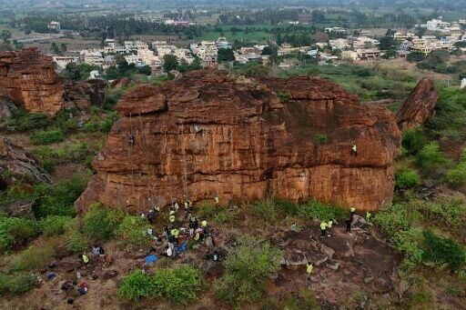 Climbers size up a rock wall in Karnataka state, India