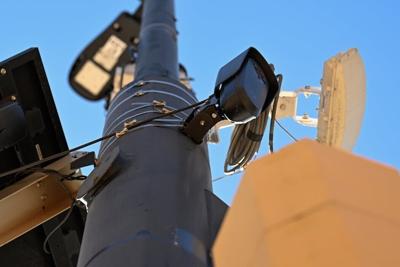 A small, black license plate recognition camera is mounted on a light pole in Boulder, Colo.