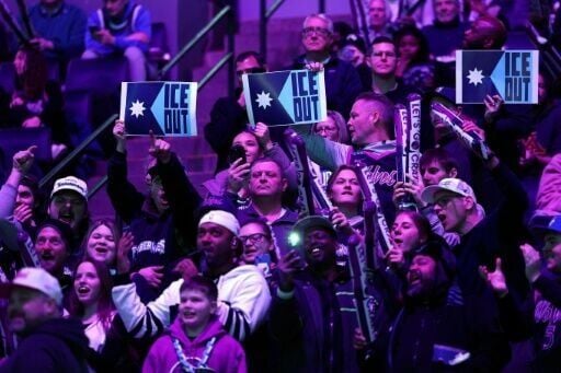 Fans hold signs protesting the presence of federal immigration agents in Minneapolis during the NBA game between the Minnesota Timberwolves and Golden State Warriors