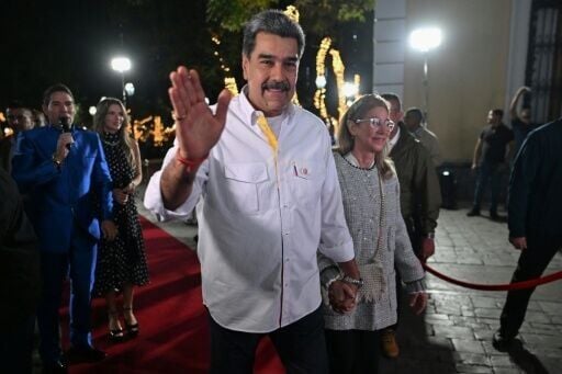 Venezuela's President Nicolas Maduro and his wife Cilia Flores wave to supporters in Caracas