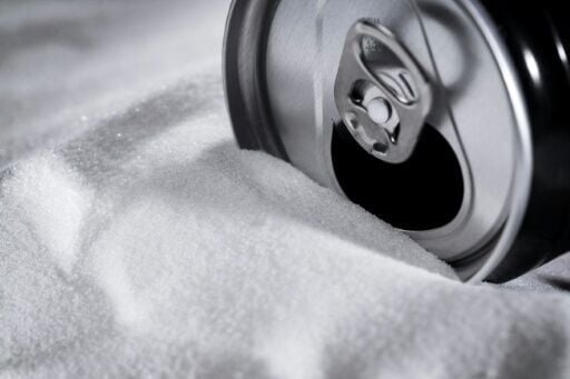 A soft drink can sitting on a bed of sugar. The WHO wants taxes raised on sugary drinks