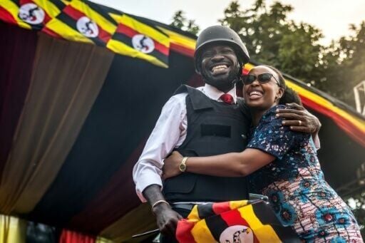 Bobi Wine (L), embraces his wife Barbara Kyagulanyi (R) at the rally