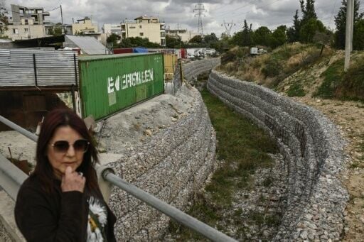 The contested anti-flooding technique entails shoring up the stream's banks with gabions and pouring concrete sections of the river