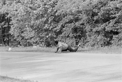 James Meredith looks at Aubrey Norvell, partially hidden behind foliage, after Norvell shot him in Hernando, Miss., on June 6, 1966.