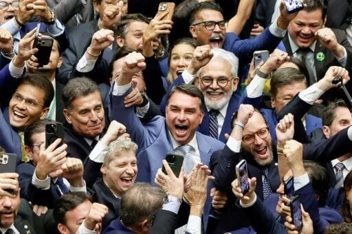 Senator Flavio Bolsonaro (C) celebrates in Congress after a vote that overturned a veto of a bill substantially reducing his father Jair Bolsonaro's sentence