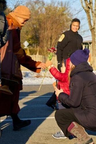 Bhikkhu Pannakara (L), leading Buddhist monks in a "Walk for Peace," receives a flower from a child as they walk in Richmond, Virginia