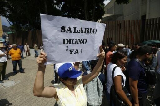 A banner reads 'decent wages now' at a protest by teachers and students in Caracas