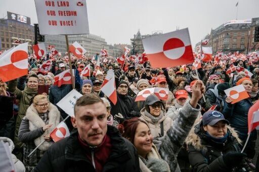 Protesters wave Greenlandic flags as they take part in a rally at city hall in Copenhagen